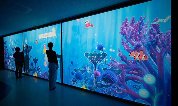 画像：「Let it Swim! 泳がせよう！私が描く海のいきもの」。紙に描いた生き物の絵が、大きなスクリーンで自由に動く。紙アプリをアレンジした体験型アトラクション。