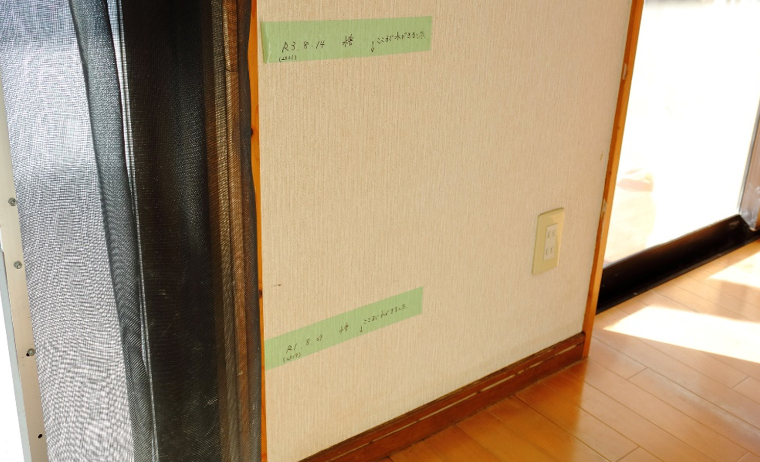 画像：テープで記された2019年（下）と2021年（上）の浸水高さ。2021年は事務机の下まで浸水した。